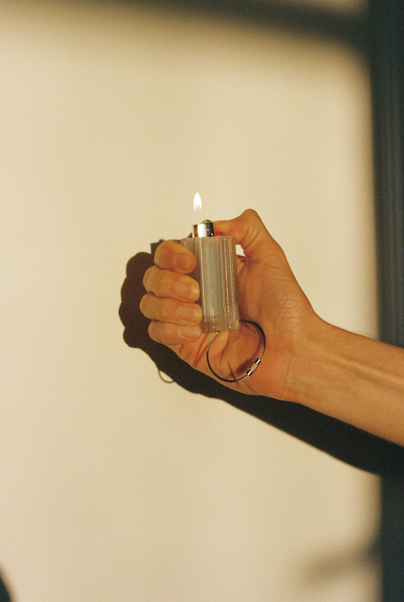 Hand holding a lit lighter.