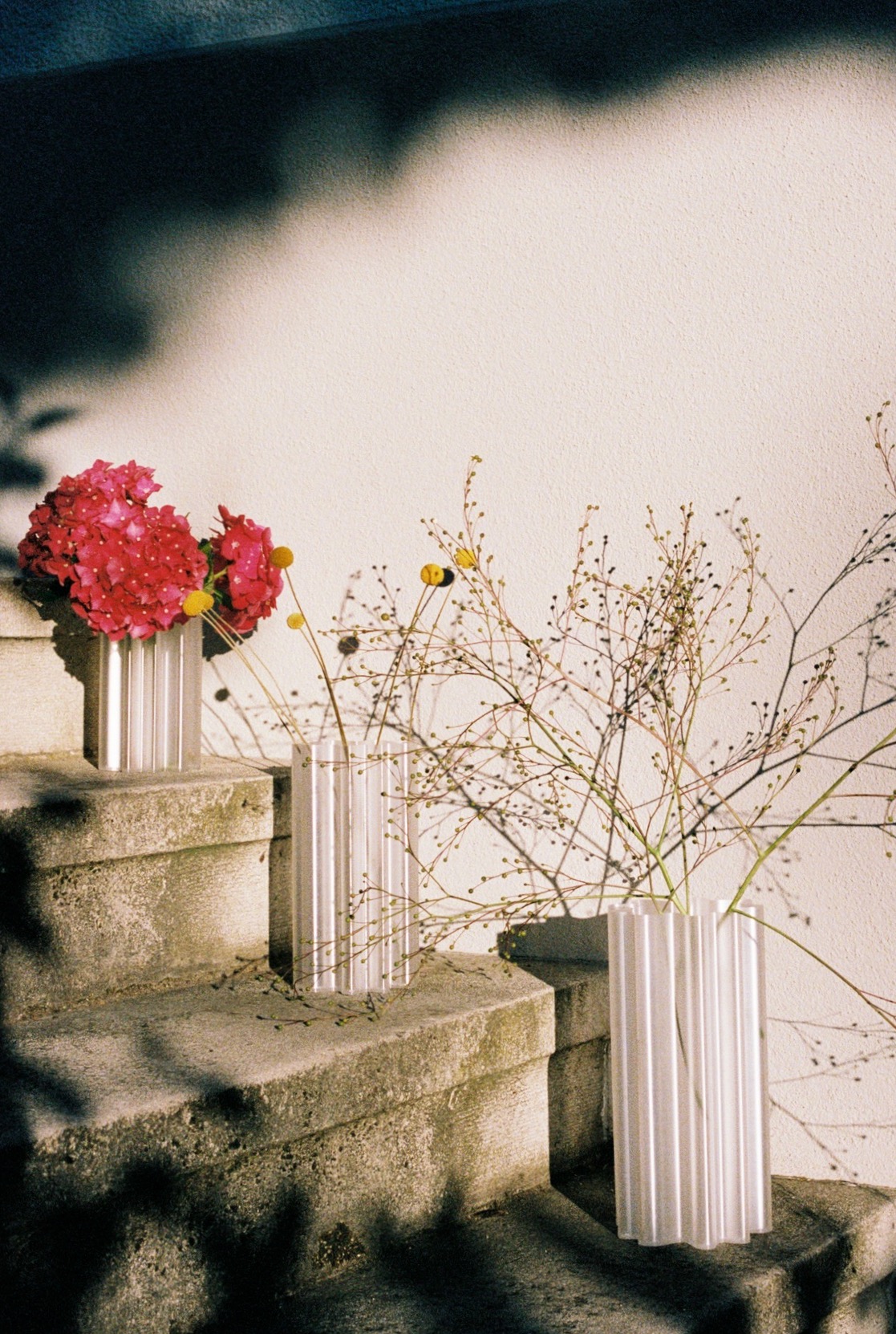 Vases with flowers on stone steps.