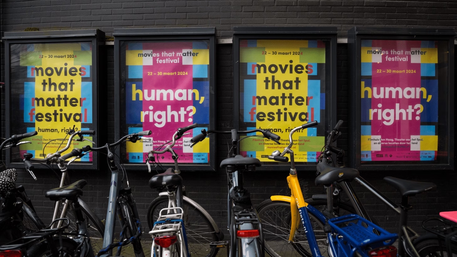Movies That Matter Festival posters next to parked bicycles.